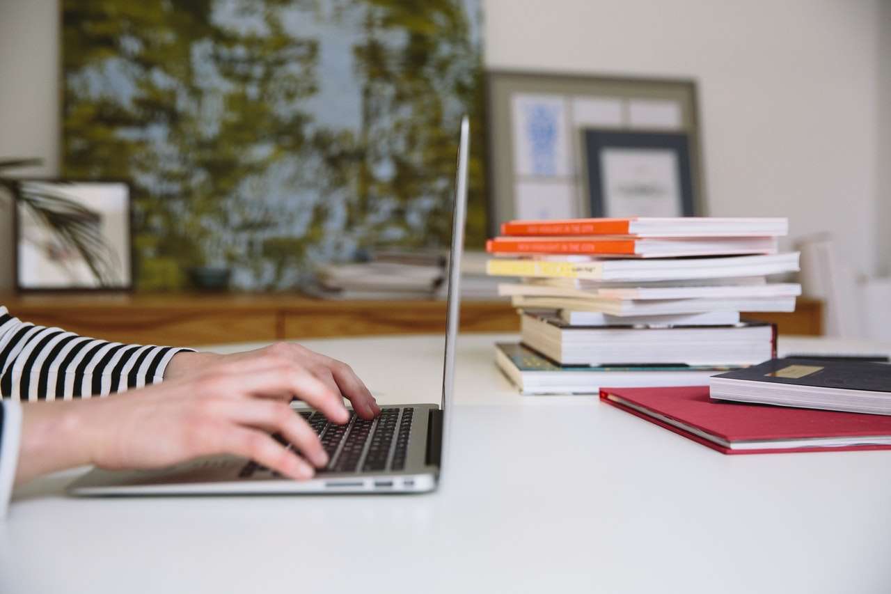 Person using a laptop to research the best places to live in Wheat Ridge, Colorado