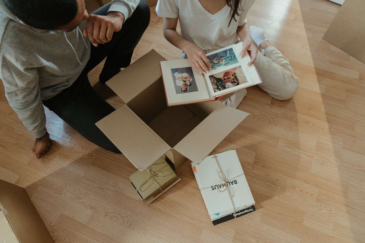 two people packing photo albums for moving